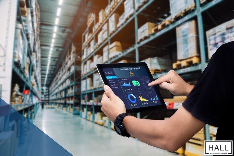 A warehouse worker using a digital inventory management system, highlighting the impact of Texas inventory tax on businesses