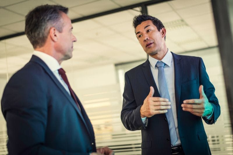 Two businessmen discussing CFO vs COO services