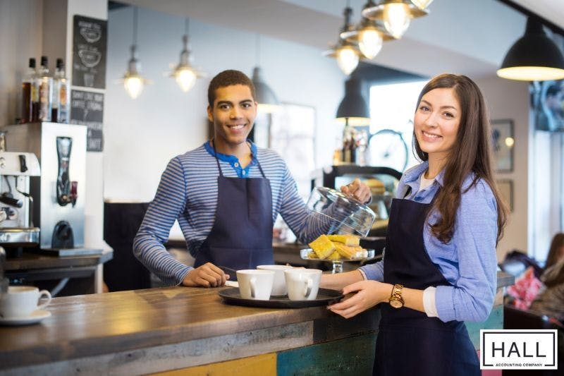 Two smiling individuals working part-time, a common context for side work income that may require tax considerations.