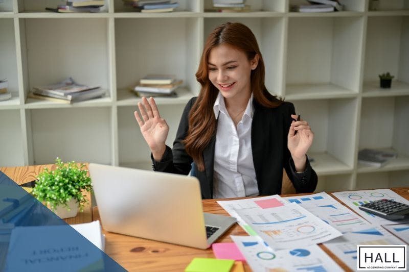 Professional woman reviewing financial documents on a laptop, exploring tax debt relief options.