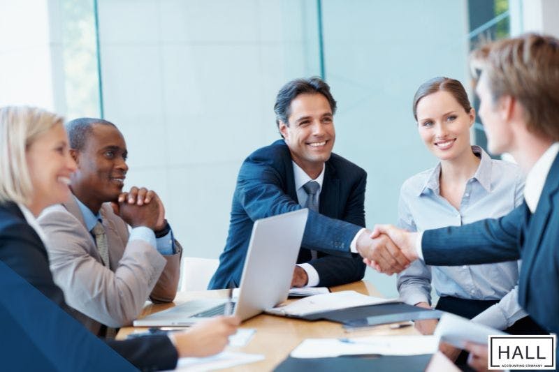 Business professionals discussing finances in a meeting, illustrating how much does bookkeeping cost.