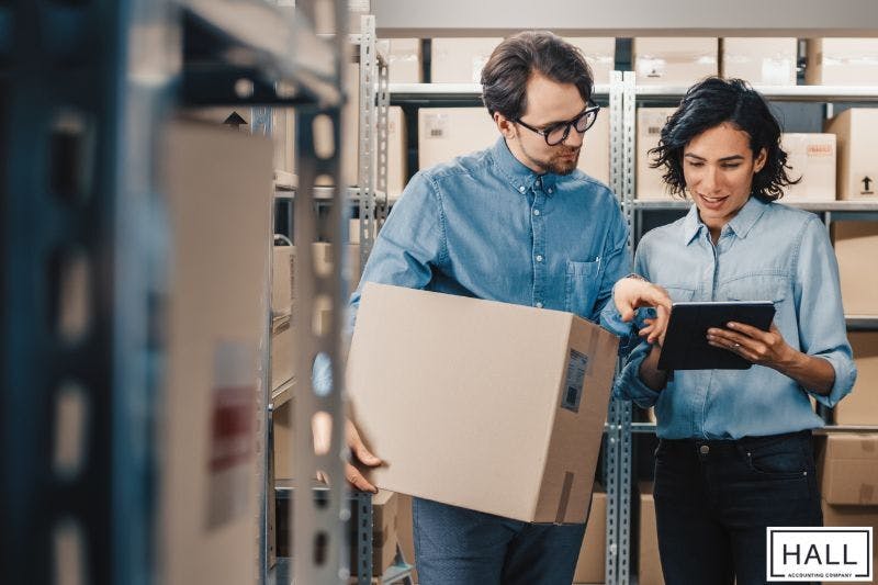 Small business owners reviewing inventory and finances, reflecting how much does bookkeeping cost to manage