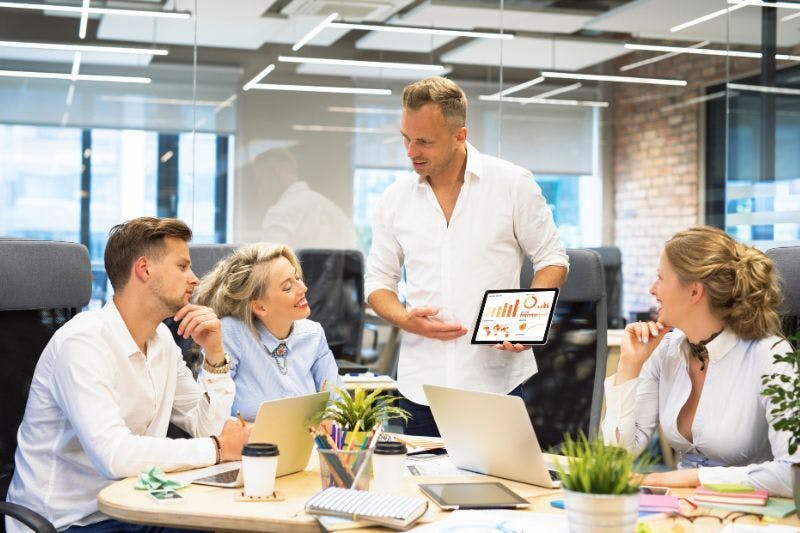 Expert explaining year-over-year growth metrics on a tablet to colleagues