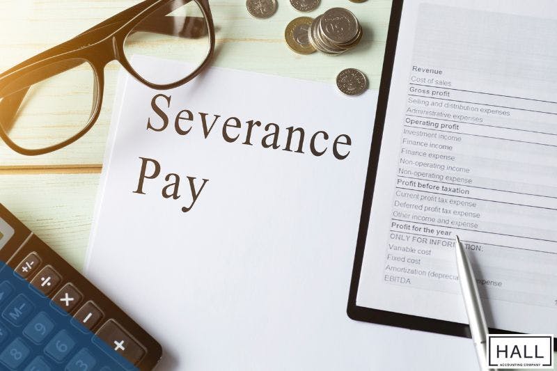 Severance pay document with financial papers, calculator, glasses, and coins, symbolizing taxable income and bonus reporting