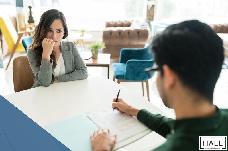Anxious woman consulting a tax professional about the penalty for filing wrong income tax return, highlighting financial consequences and solutions