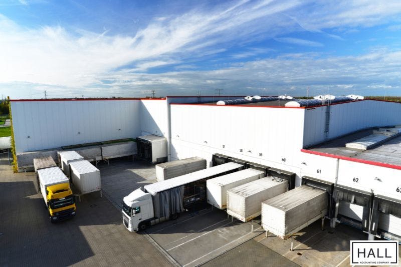 Trucks at a logistics center, illustrating business shipping costs and sales tax in San Antonio, Texas.