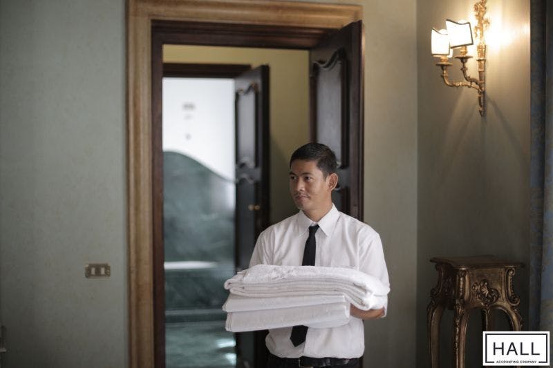 Hotel staff carrying towels, representing hospitality industry impacted by sales tax in San Antonio, Texas.
