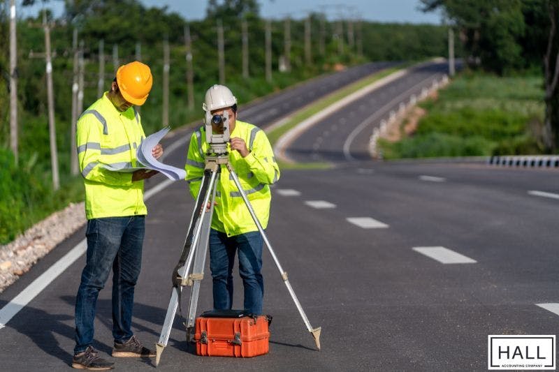 Engineers reviewing plans on highway project impacted by sales tax in San Antonio, Texas.