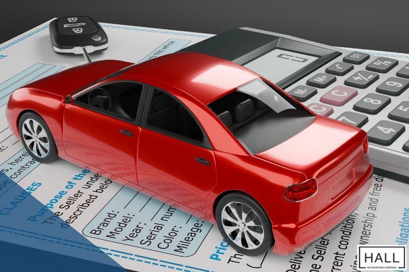 A toy car, car keys, and a calculator on a document, relevant to the tax benefits of leasing vs. buying a car for business