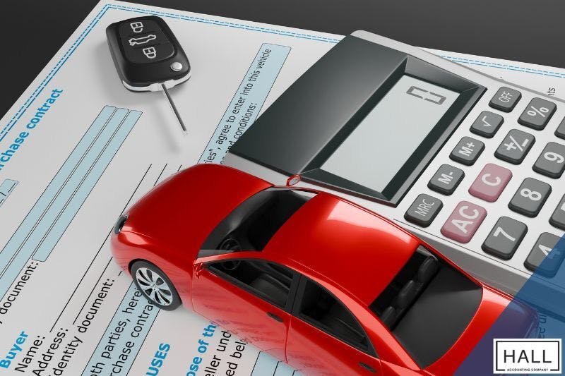 A car purchase contract, calculator, and car key on a desk, suggesting potential tax implications for small businesses