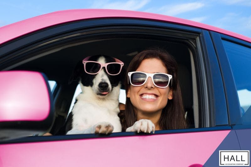 A cheerful entrepreneur enjoys the benefits of exploring tax loopholes for small business while driving her stylish pink car