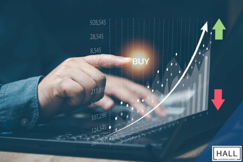 A hand pointing at a rising stock chart, symbolizing financial growth and the importance of tax planning for high-net-worth individuals.