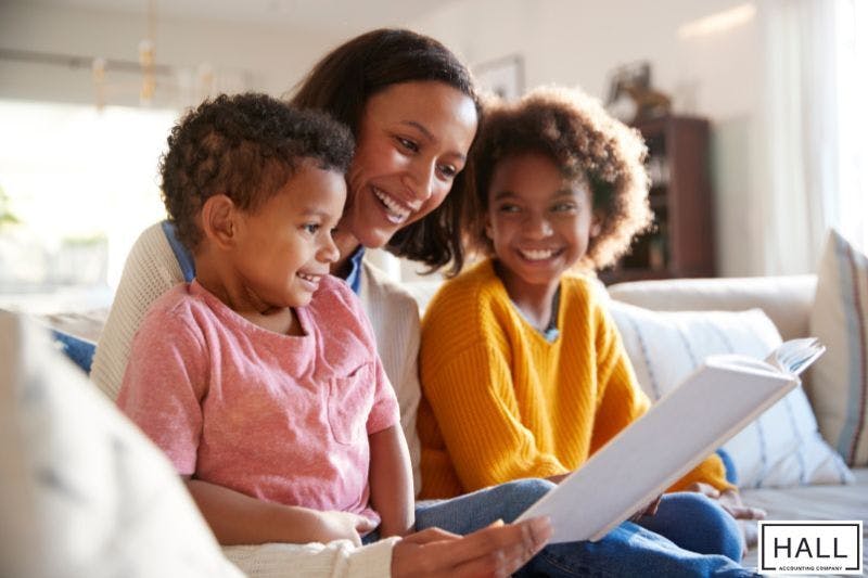 A mother and her two children reading together at home, illustrating what are dependent exemptions when it comes to taxes
