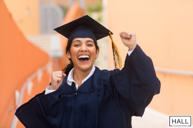 A joyful graduate celebrates, illustrating what are dependent exemptions when it comes to taxes and how education-related tax benefits apply