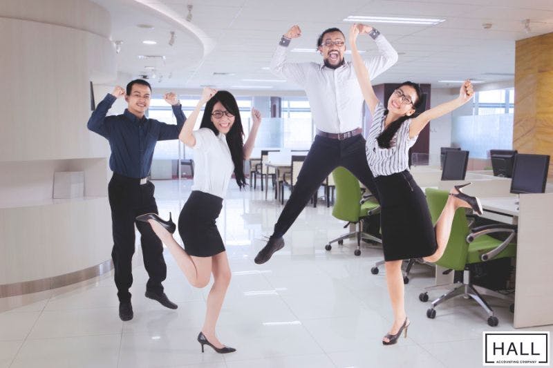 Excited office employees celebrating, symbolizing tax refunds or financial relief