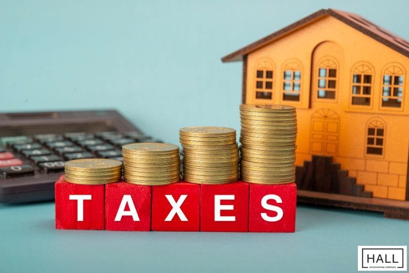 A pile of coins sits on top of a red block with the word