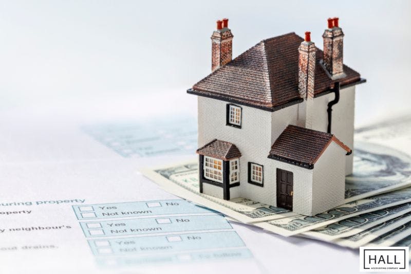 model house sits on top of a green dollar bill visible illustrating Property Tax Due