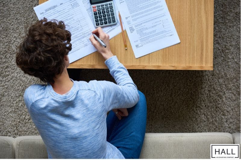 Person calculating taxes at home—why is receiving a large tax refund a bad thing?