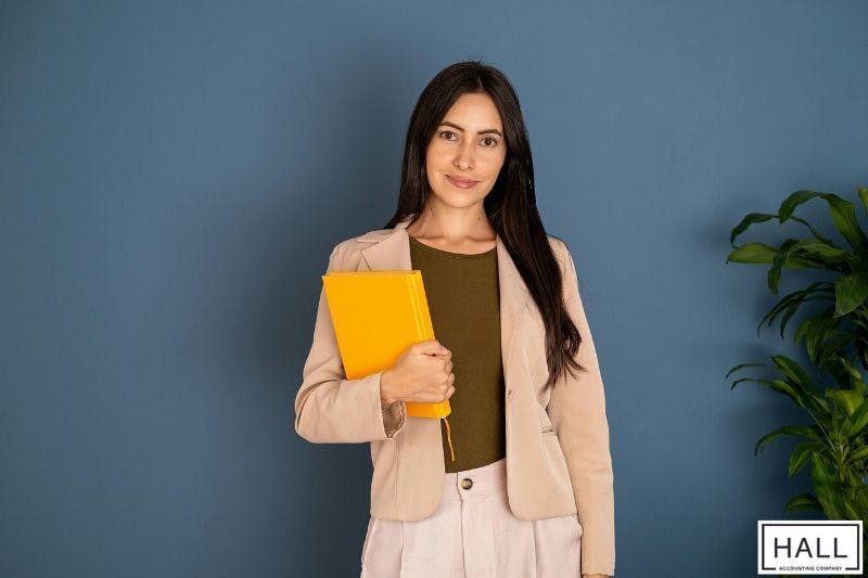 Confident woman with tax documents—why is receiving a large tax refund a bad thing?